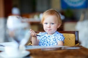 Une toute petite fille en train de manger.