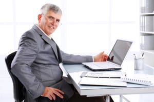 un senior travaille sur ordinateur