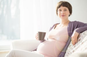 Une femme enceinte assise sur un canapé