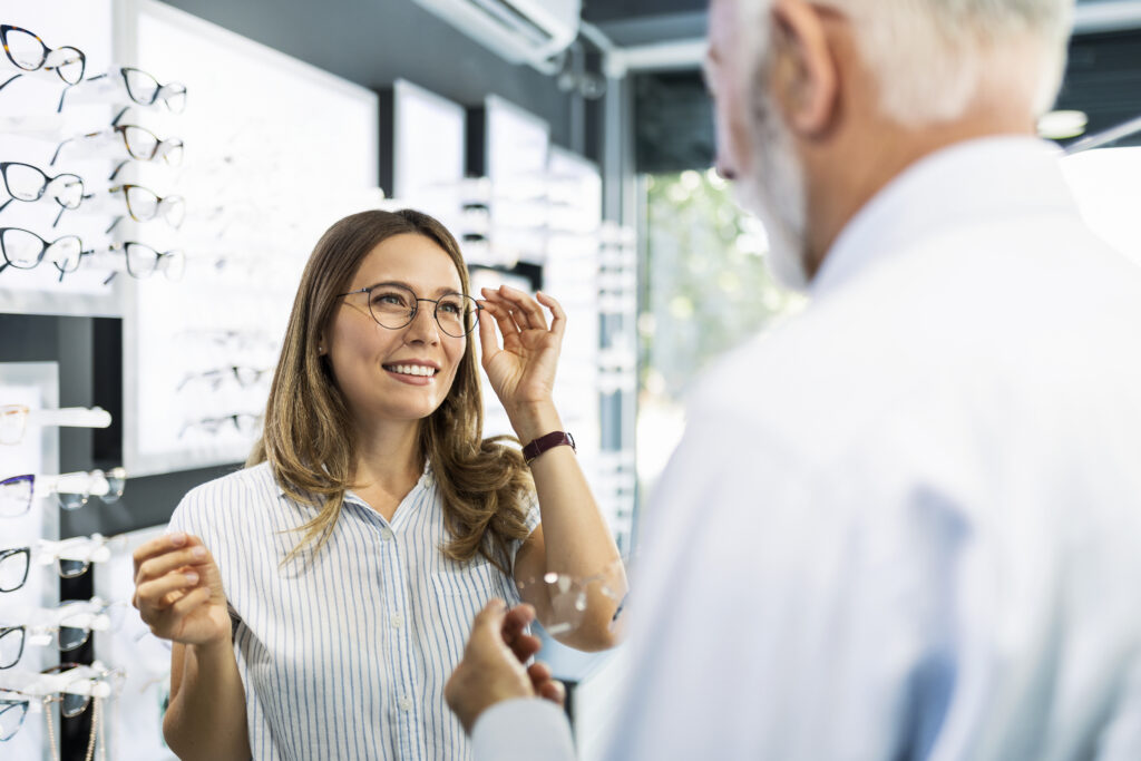 Femme qui essaie des lunettes chez un opticien