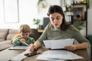 Jeune maman qui calcule le coût de son assurance de prêt