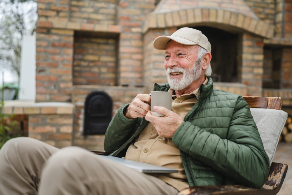 Homme de 70 ans qui boit un café à l'extérieur