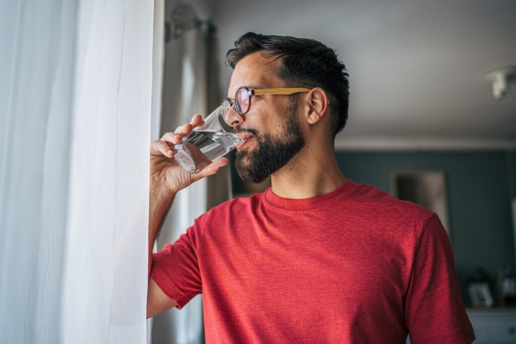 Homme avec des lunettes qui regarde par la fenêtre