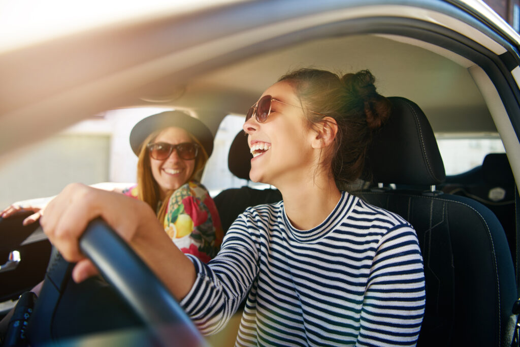 Jeunes femmes souriant en voiture et portant des lunettes de soleil