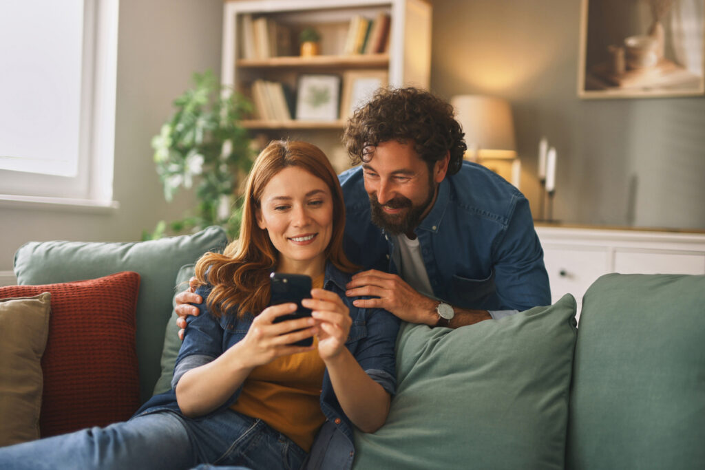 Refuser la mutuelle d'entreprise : photo d'un couple qui regarde un smartphone